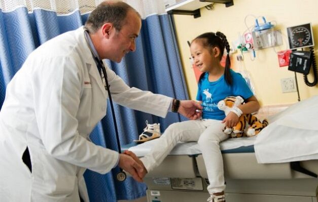 the doctor examines a child with hip arthrosis